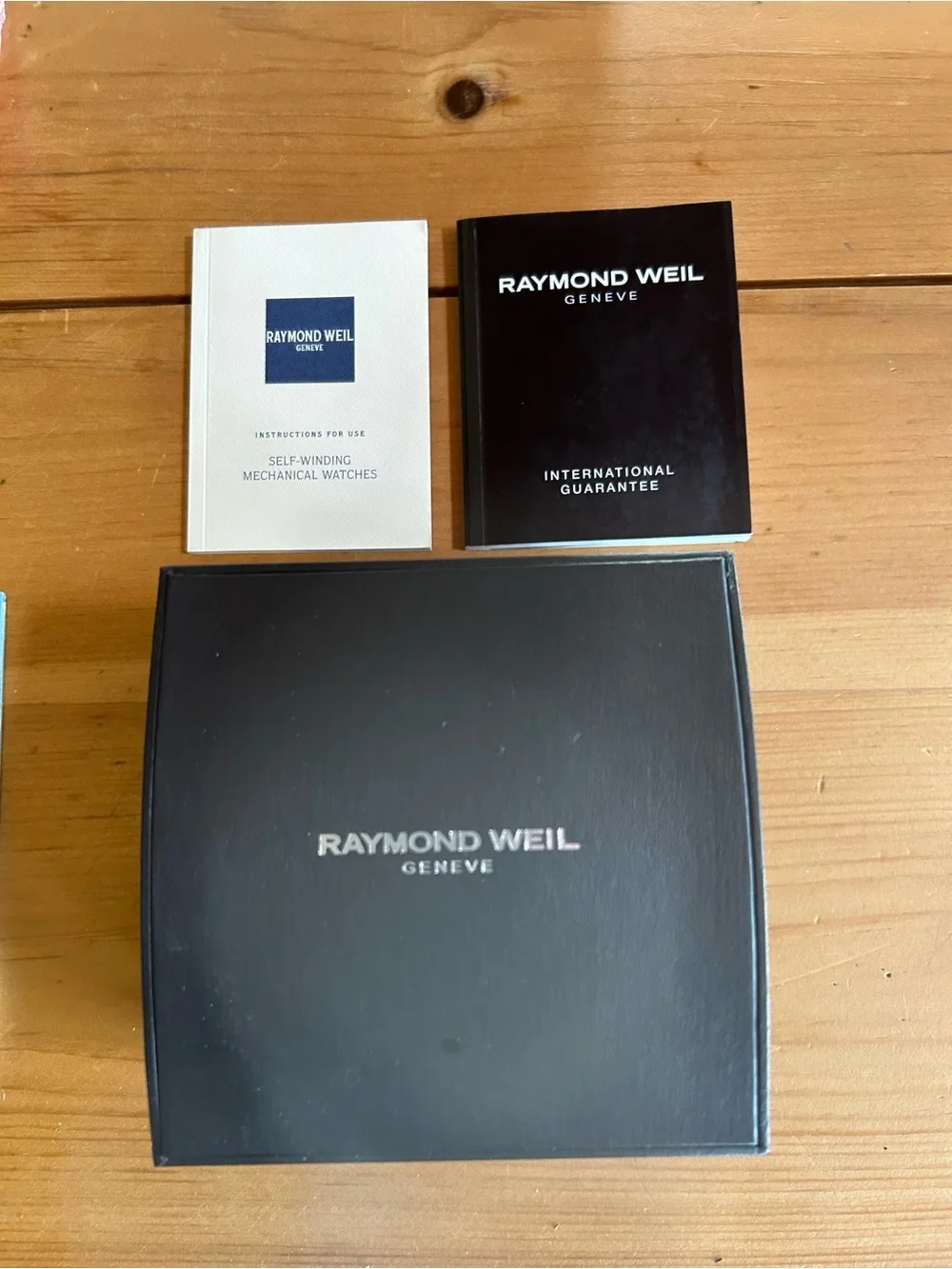 Raymond Weil Geneve silver watch with dark grey face.